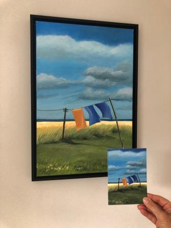 Acrylic painting of washing on a communal line blowing in the wind, by the sea. Clouds are racing across a blue sky and the grasses are being blown by the wind